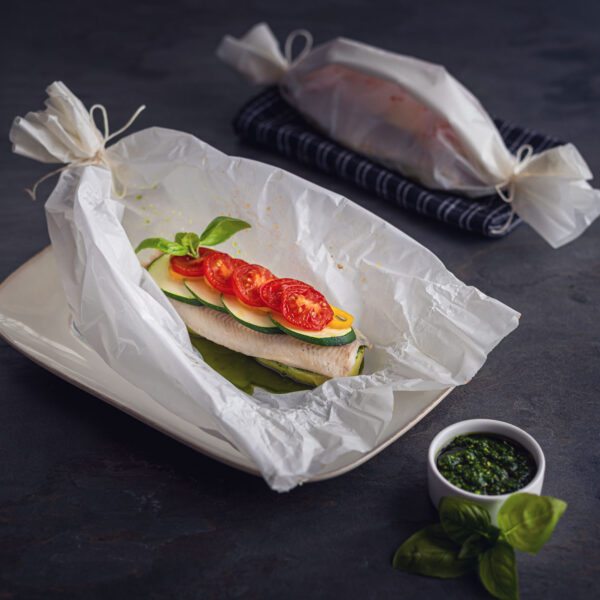 Forellenfilet-Backpapier-Gemuese auf Schieferplatte