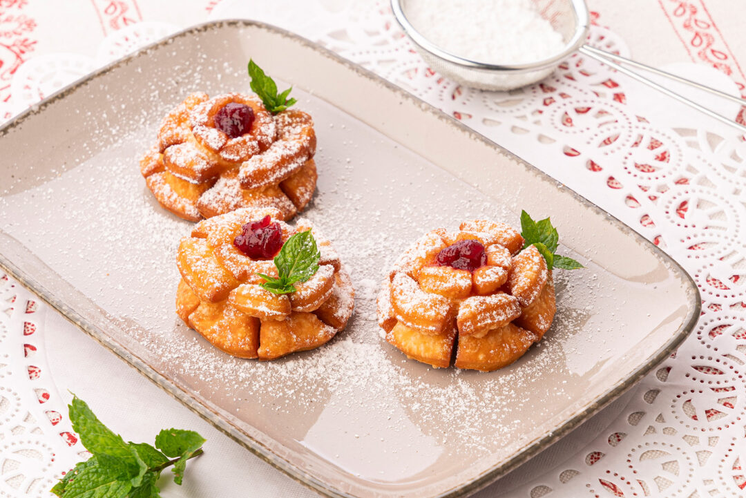 Drei Rosenkrapfen auf hellem Teller