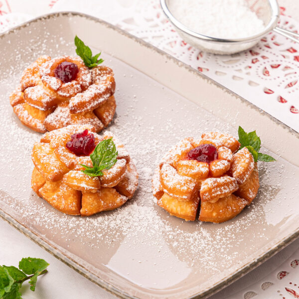 Drei Rosenkrapfen auf hellem Teller