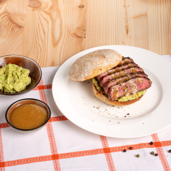 Sandwich mit Steak auf karrierter Tischdecke