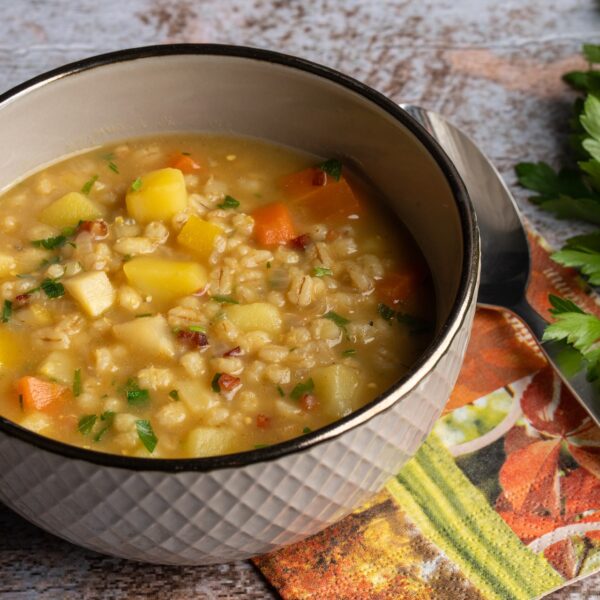 Rollgerstensuppe in Topf auf mamorierter Arbeitsplatte
