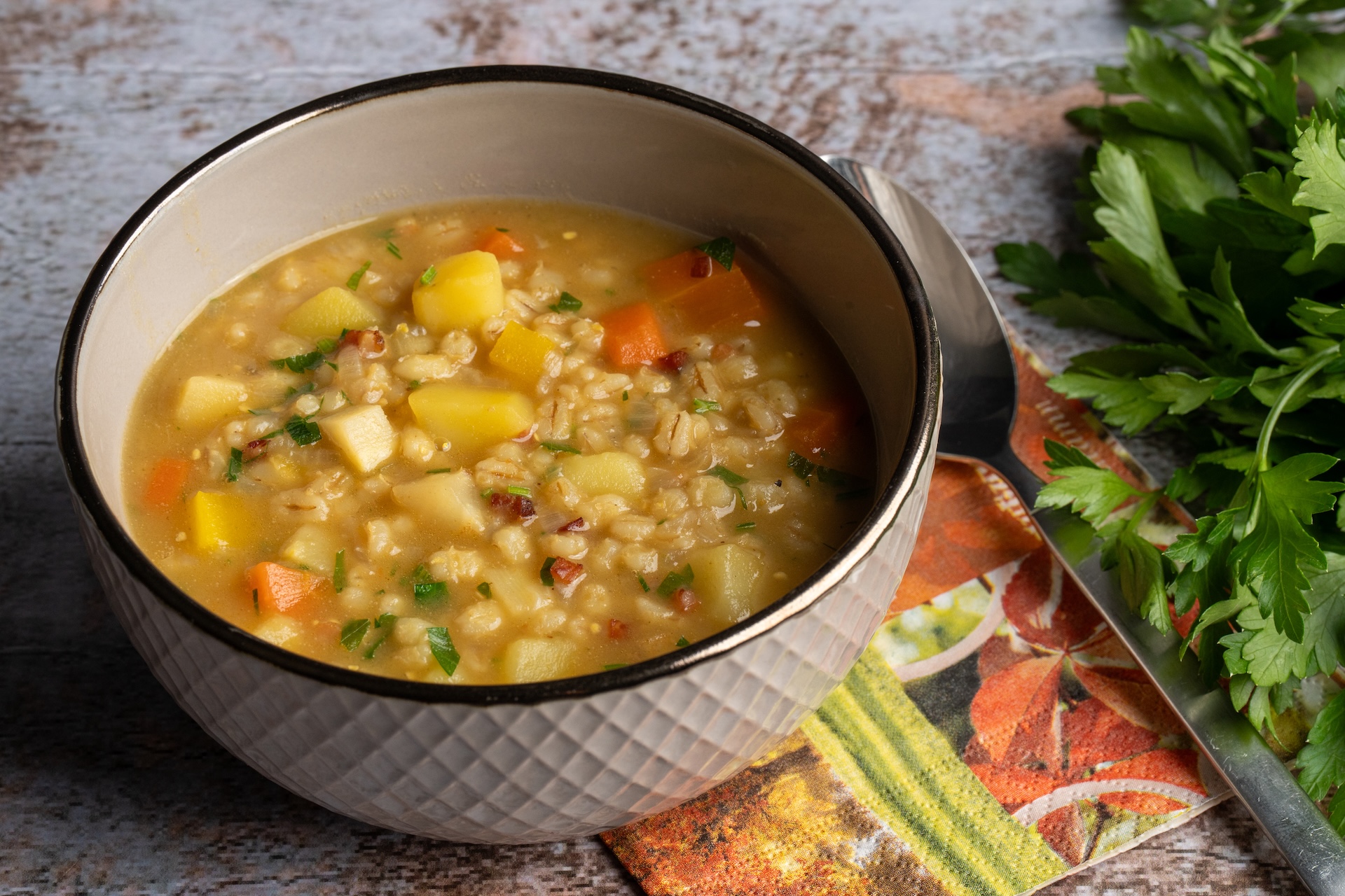 Rollgerstensuppe in Topf auf mamorierter Arbeitsplatte